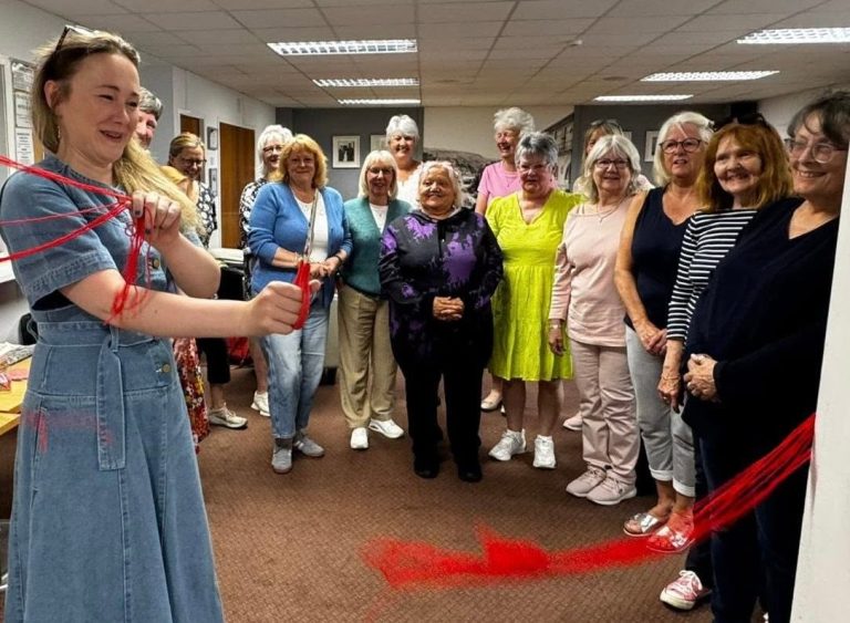 Cutting the yarn at the opening of Largs SWI Yarn Club with members