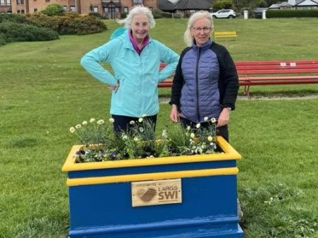 Members of Largs SWI maintaining community flower planters at Cairnies Quay in Largs