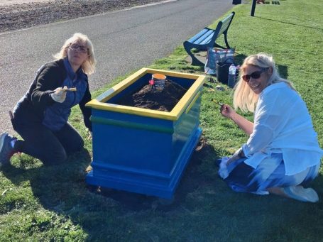 Members of Largs SWI maintaining community flower planters at Cairnies Quay in Largs
