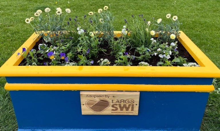Members of Largs SWI maintaining community flower planters at Cairnies Quay in Largs