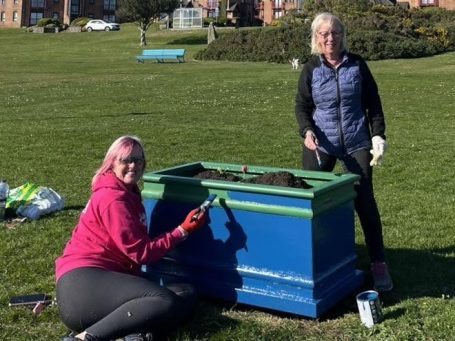 Members of Largs SWI maintaining community flower planters at Cairnies Quay in Largs